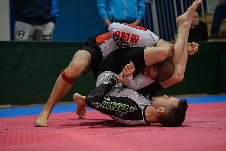 Two BJJ grapplers rolling on the mats